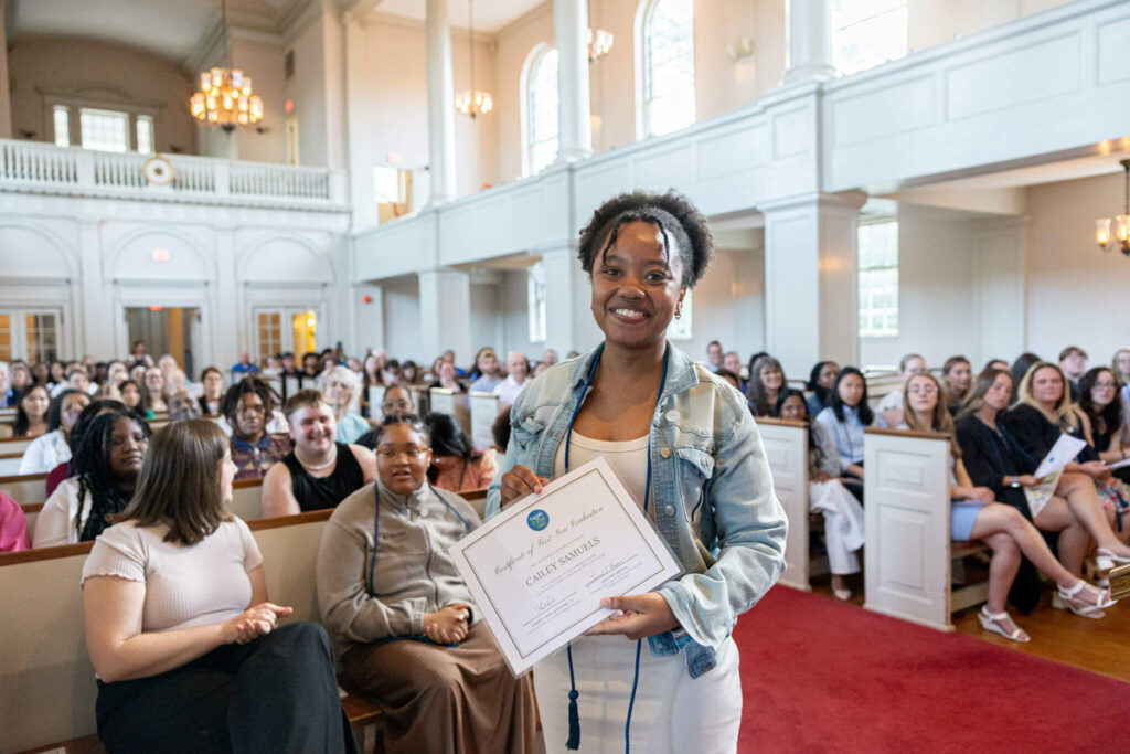 Student holding certificate in Chapel